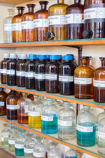 Rows of fluid chemicals in bottles at a laboratory